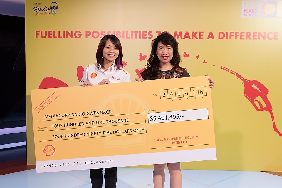 A Shell Singapore representative presents a cheque of $401,495 in donations to Ms Debra Soon, Chairperson, Mediacorp’s Radio 80 Committee