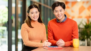Chinese male and female standing at the desk