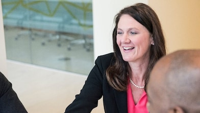 A female experienced professional at Shell smiling during a meeting.