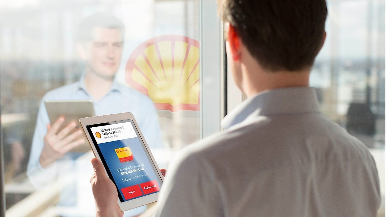  Man holding a Tab while looking at mirror