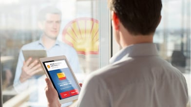  Man holding a Tab while looking at mirror