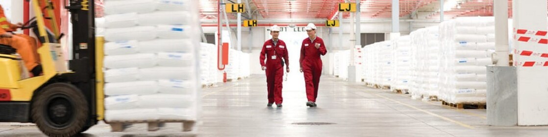 two employees walking in a factory