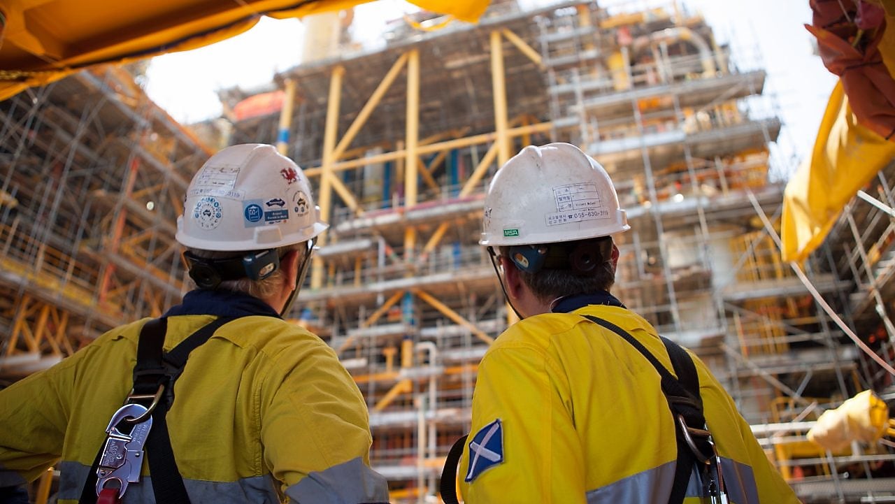 Two men looking at construction of a platform