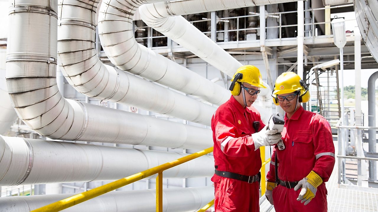 Two engineers having a discussion in the refinery plant.