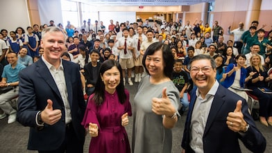 Secondary school students, educators from Nanyang Polytechnic and Science Centre,  and Shell representatives gather for a group photo at the Shell NXplorers Carnival 2025 event, giving thumbs-up to the camera.