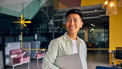 Person carrying a laptop in a collaborative office environment, representing entrepreneurship, innovation and business growth in Shell LiveWire Singapore.