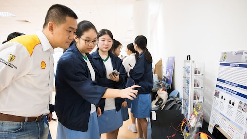 Students presenting their prototype and project display to a Shell mentor during the Shell NXplorers showcase event.