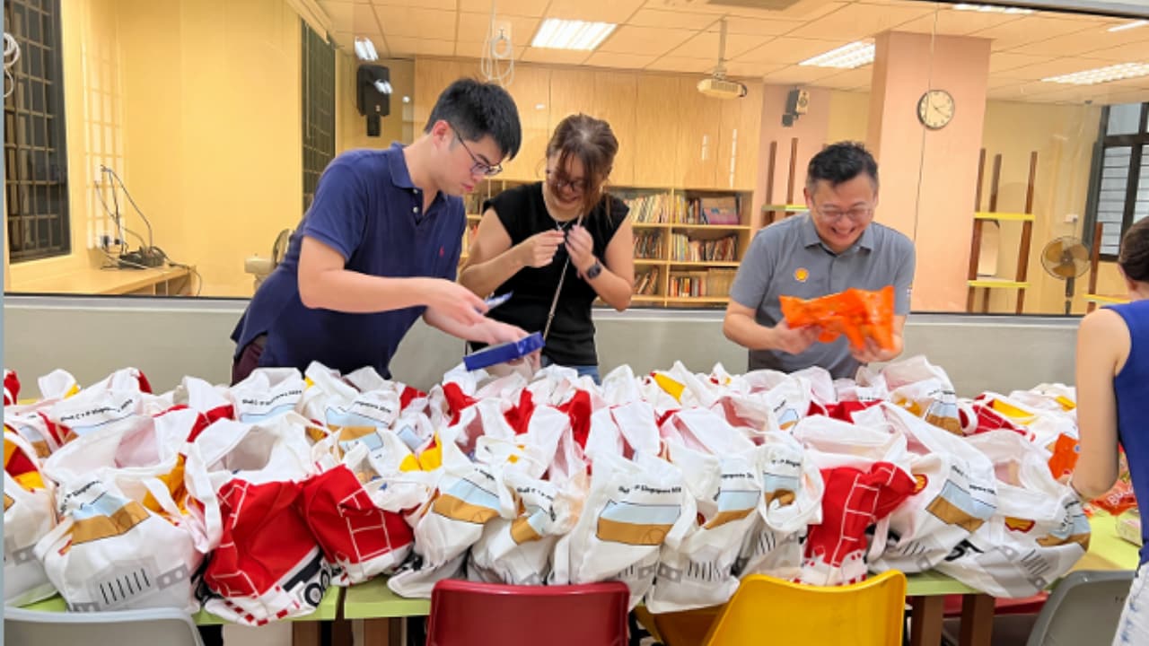 Shell Singapore volunteers pack goodie bags for children at Lakeside Student Care following a creative painting workshop and games.