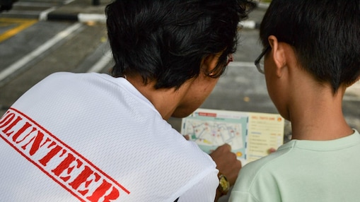 Volunteer assisting children with the mini Shell Traffic Games