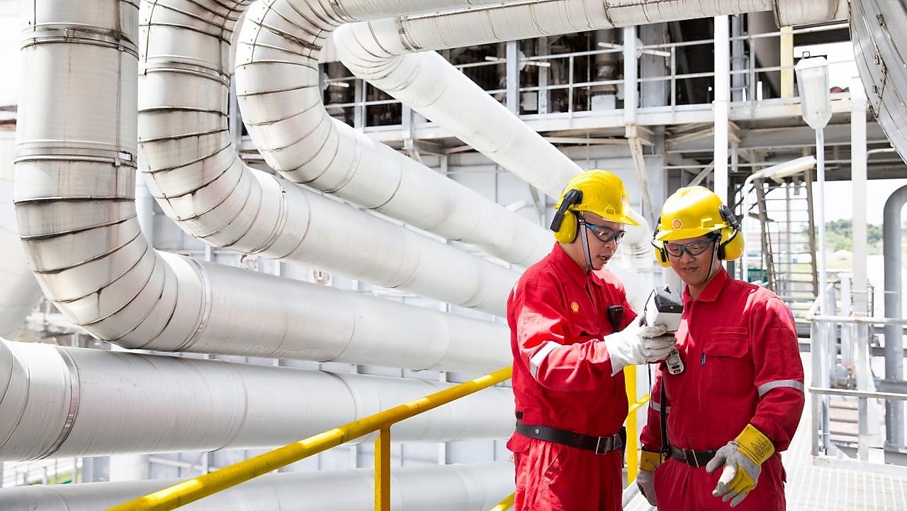 Two engineers having a discussion in the refinery plant.