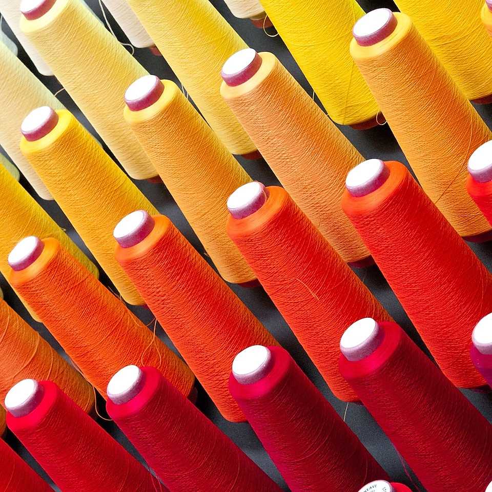 Multiple cones of cotton threads in different colours
