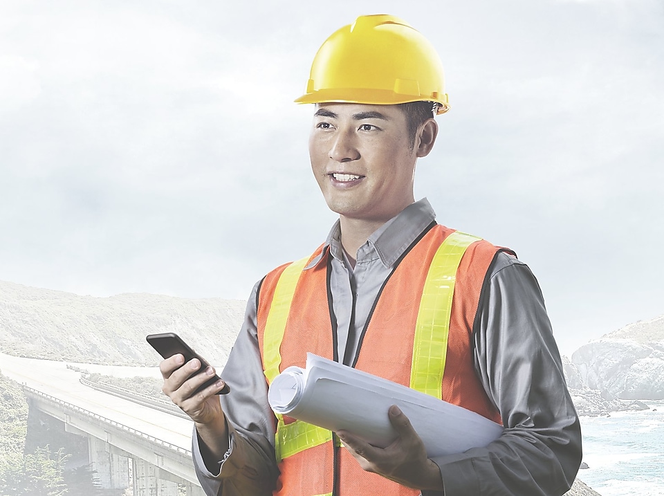 man wearing a yellow safety helmet holding a phone