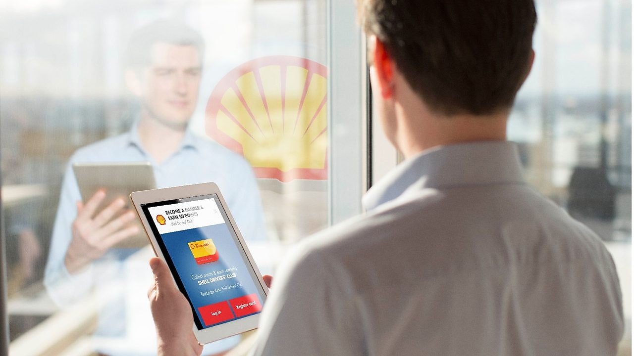 Man holding a Tab while looking at mirror