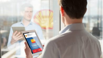 Man holding a Tab while looking at mirror