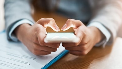 Two hands shown using a mobile device to send an email