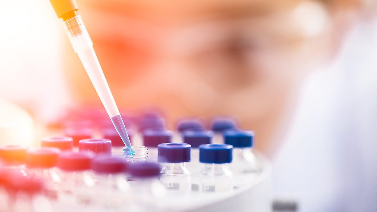 Liquid being poured into a plastic funnel by a shell scientist in a laboratory