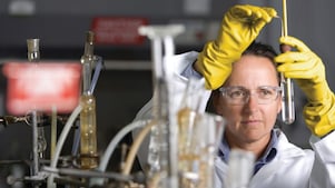 lady in safety goggles conducting a lab experiment