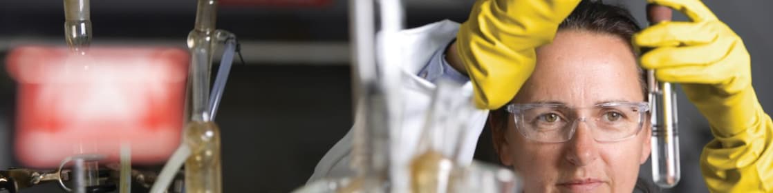 lady in safety goggles conducting a lab experiment