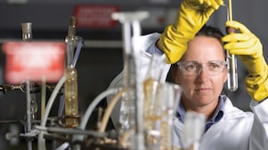 lady in safety goggles conducting a lab experiment