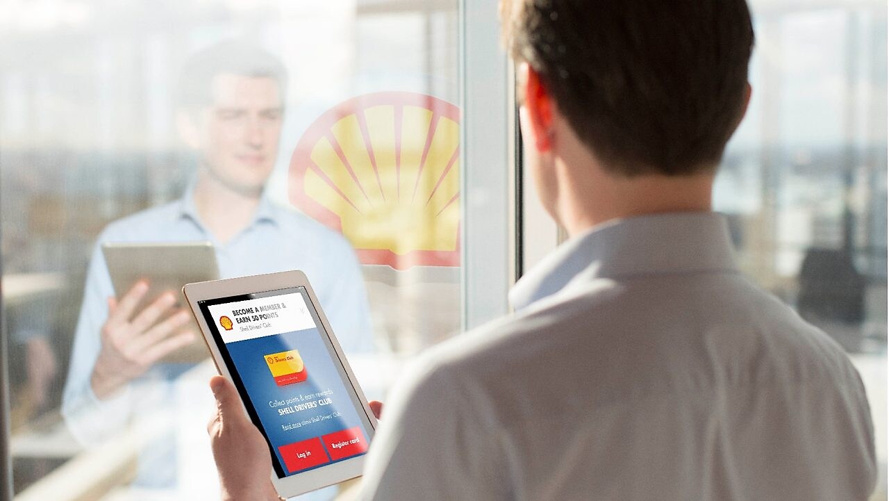 Man holding a Tab while looking at mirror