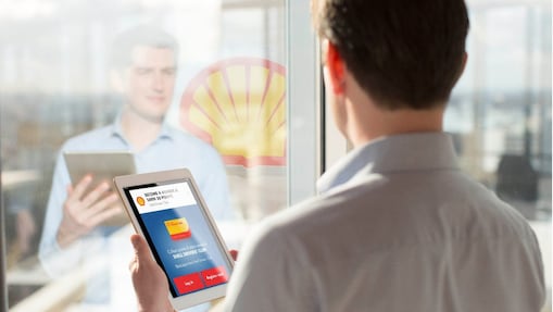 Man holding a Tab while looking at mirror