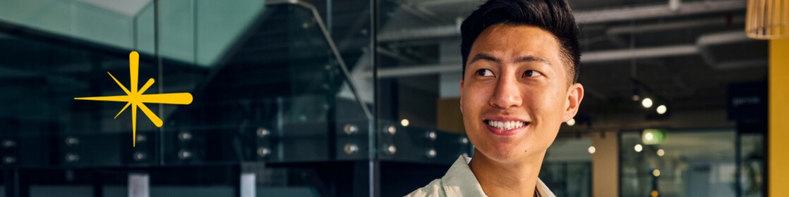 Person carrying a laptop in a collaborative office environment, representing entrepreneurship, innovation and business growth in Shell LiveWire Singapore.
