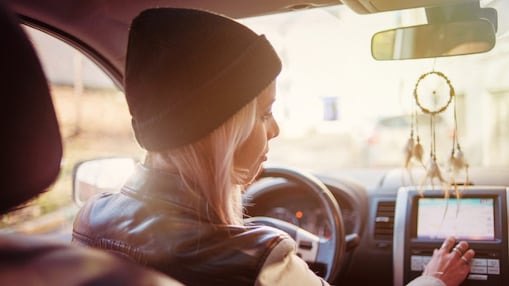 A young woman checks the instructions displayed on her car's built-in navigation screen