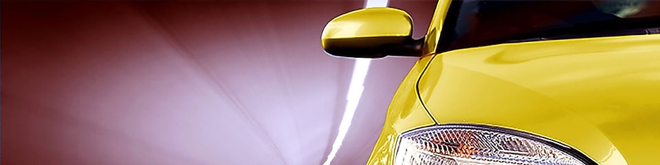 Front of a yellow car driving through a tunnel, right front light and wing mirror in view