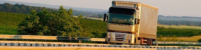 Truck driving on highway, green country background