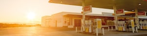 Sun rising behind a Shell station forecourt